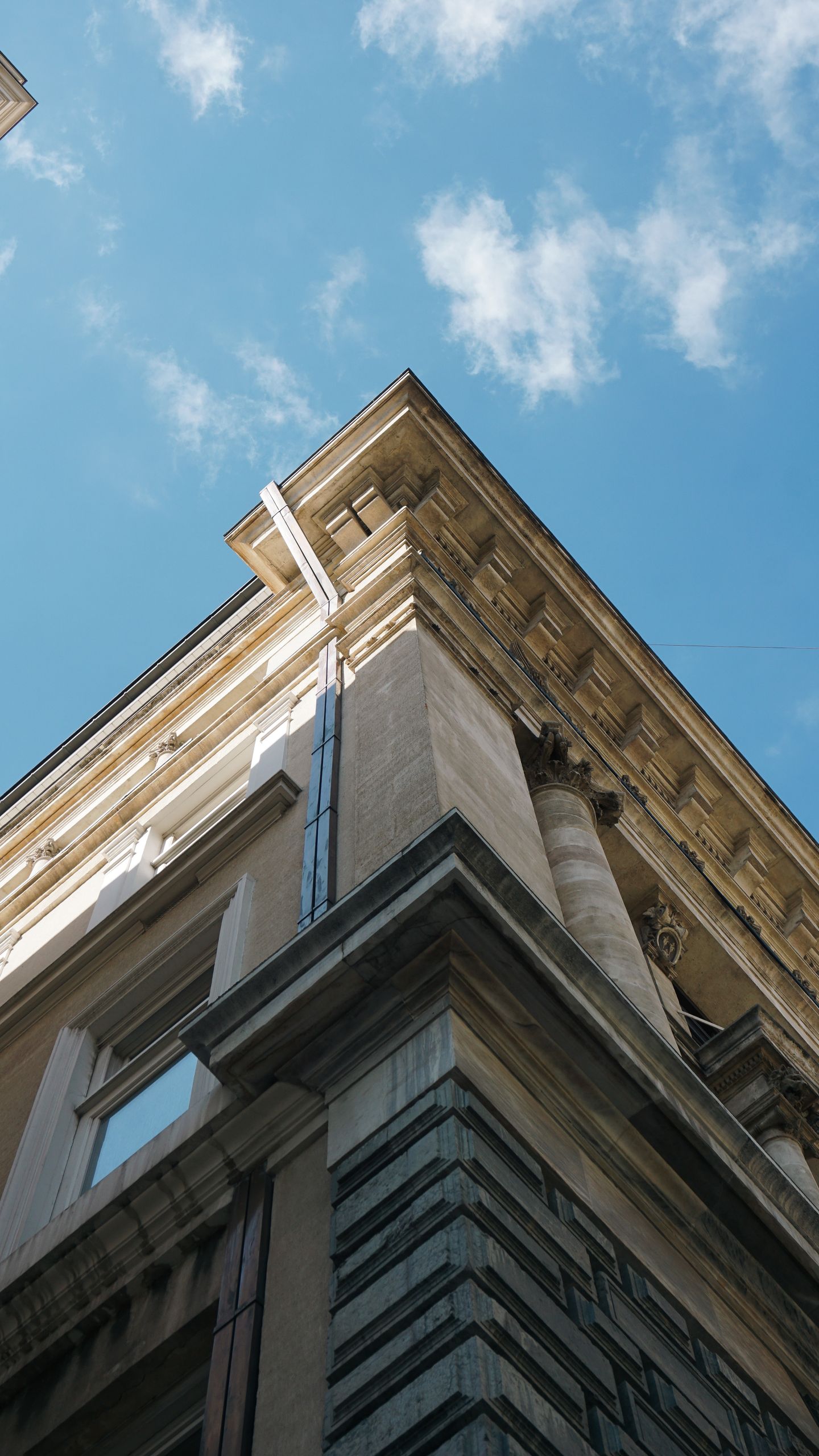Upward shot of classic architectural building against a clear blue sky.